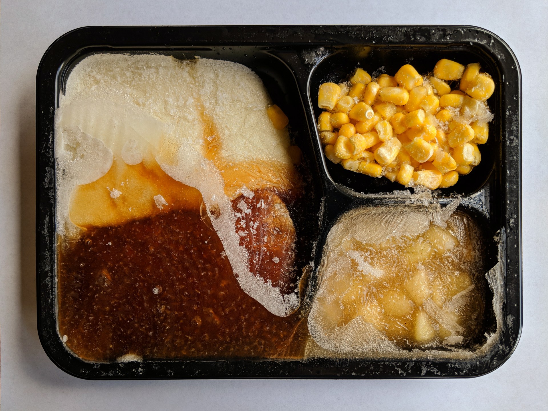 An opened, uncooked TV dinner in a divided tray, photographed in 2018.